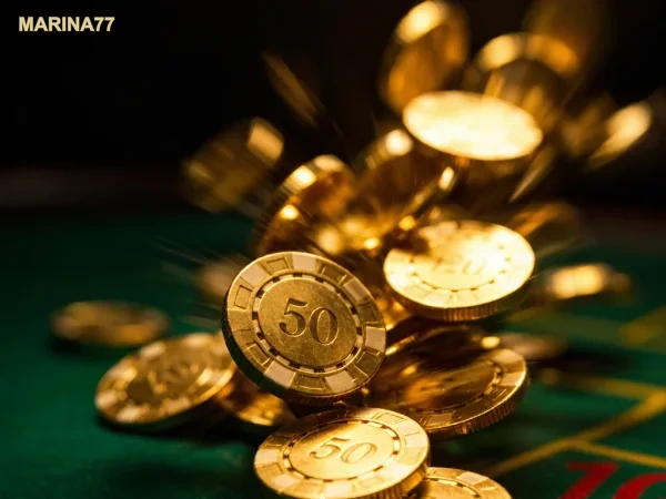 Tumpukan chip kasino berwarna emas di atas meja permainan